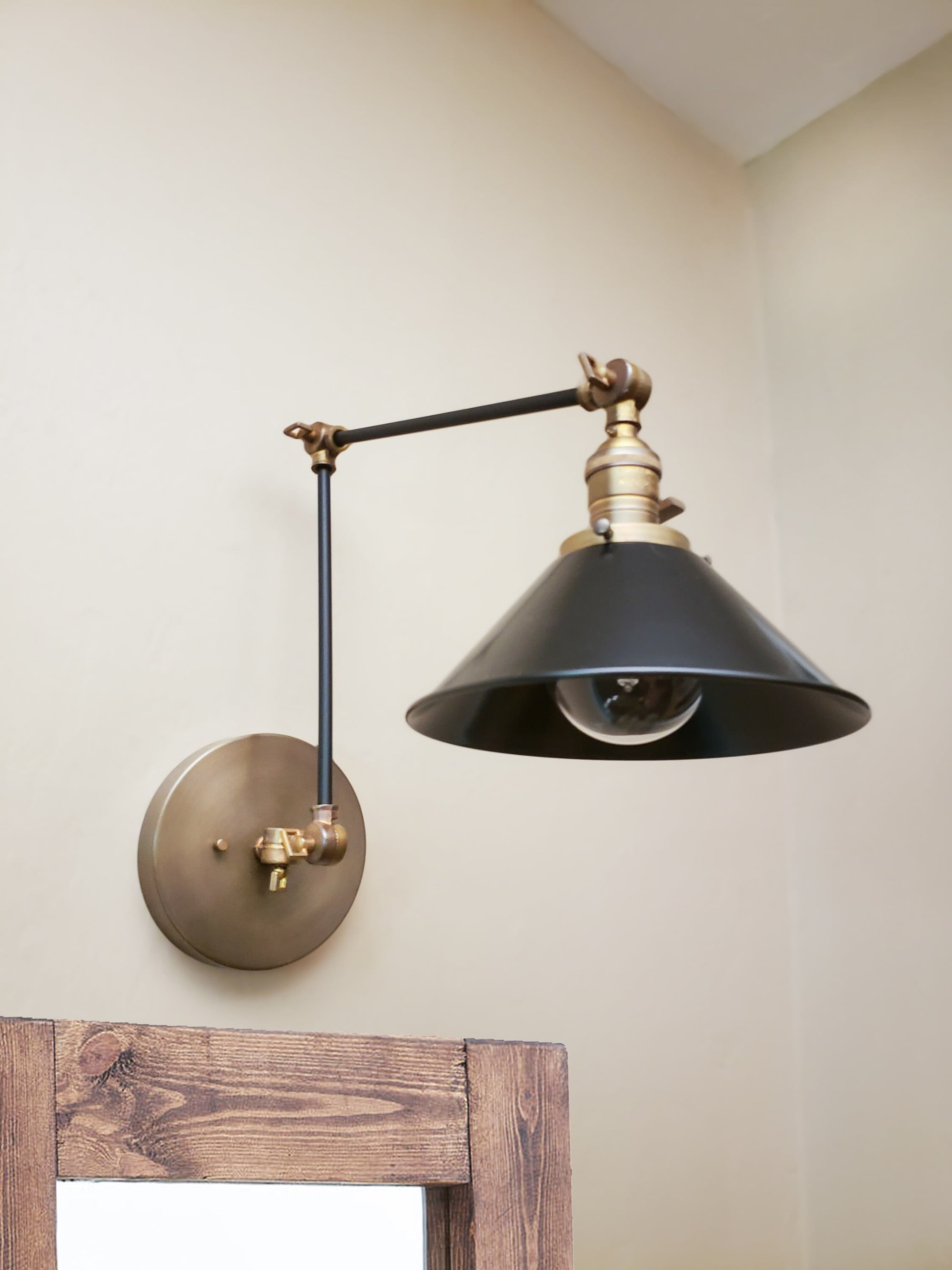 Black and brass swing arm deals sconce