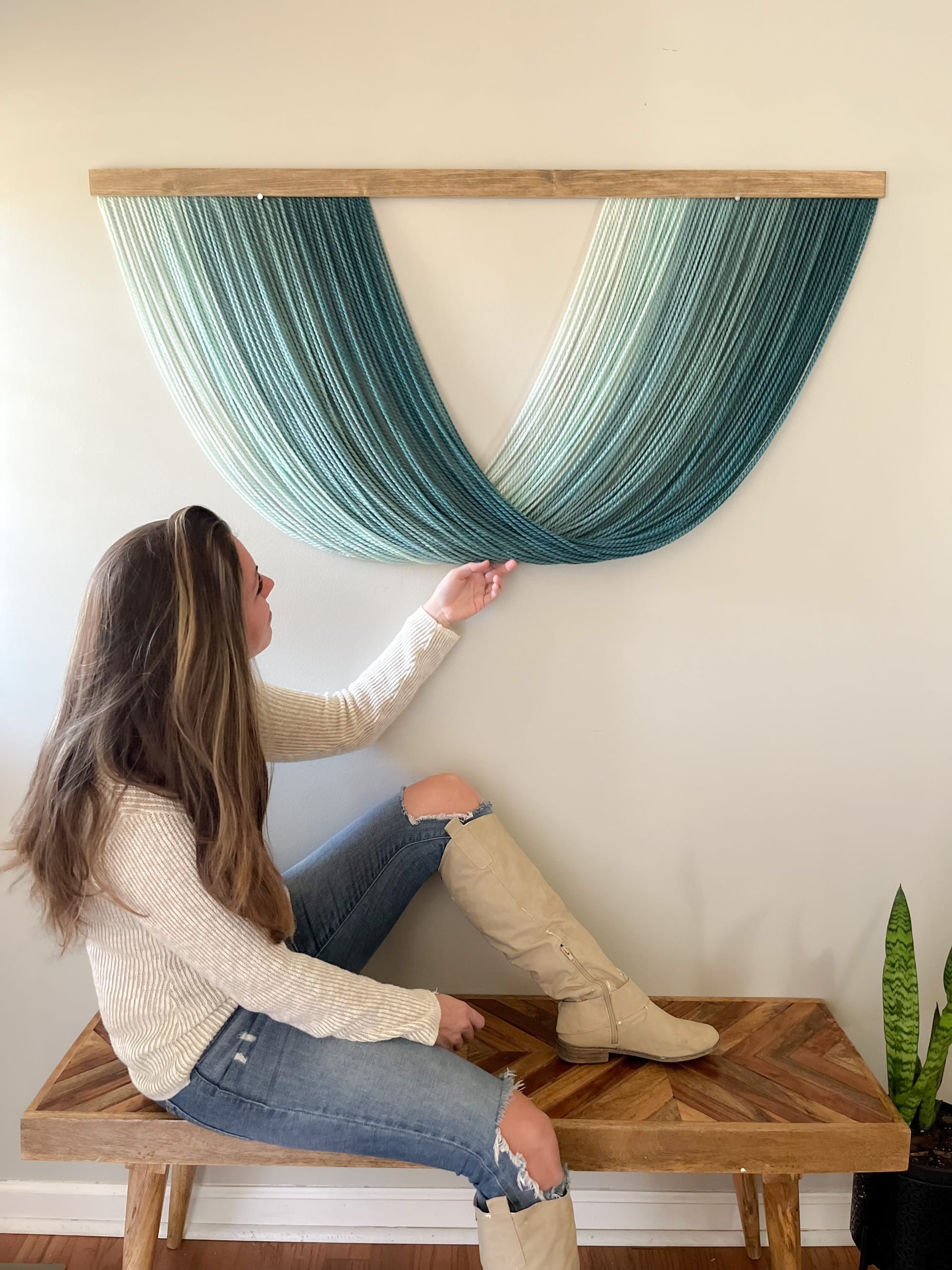 Macrame Wall Hanging In Tan With Green Plants On The Wall