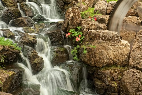 Calming waterfall with waterwheel with plants & rocks in water garden | Photography by Coblitz Creative Concepts, LLC