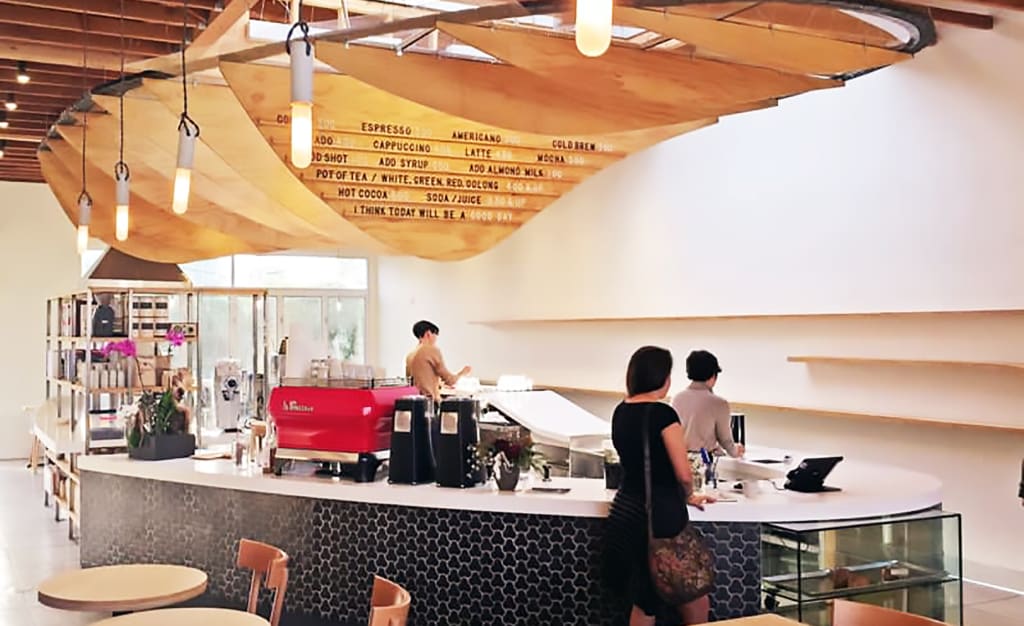 Modern Interpretation of Jurassic Skeleton Hung From Ceiling by Ryan Upton and Custom black Molded Tiles by MASS Architecture and Design in Dinosaur Coffee.