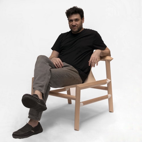 Designer Marcelo seated in a custom wood and leather armchair by Espina Corona.
