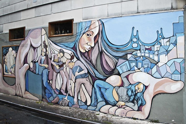 Beautiful street communal mural that says "She's got the whole world in her hands" by André Karpov in San Francisco.