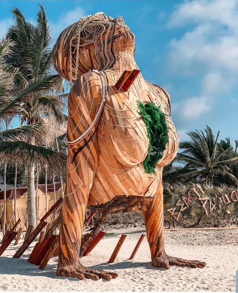 giant wooden sculpture of an upper body doing yoga