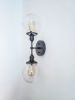 2-Arm Matte Black Modern Wall Sconce Clear Shade Industrial | Sconces by Retro Steam Works. Item composed of metal in industrial style