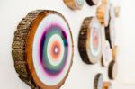 A Wall of Wooden Circle Slices | Wall Sculpture in Wall Hangings by Modern Slice. Item made of wood with synthetic