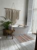 Knitted area rug with white, peach, beige, and gold stripes | Small Rug in Rugs by Anzy Home. Item made of cotton with fiber