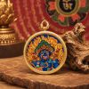 Handcrafted Blue Wealth Deity Thangka Amulet Pendant Art | Ornament in Decorative Objects by Dynasty Artisan. Item composed of metal in eclectic & maximalism or asian style