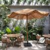 A large natural-fiber patio umbrella with a black base stan | Ornament in Decorative Objects by GoldencoirVietNam LLC. Item made of wood with fiber works with boho & country & farmhouse style
