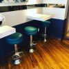 Floor Mounted Bar Stools - Model 6050-302 | Chairs by Richardson Seating Corporation | Bluewater Grill in Santa Barbara. Item composed of brass and leather
