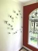 clay birds with pigment mounted on wall | Sculptures by Susan Hostetler Studio. Item composed of ceramic